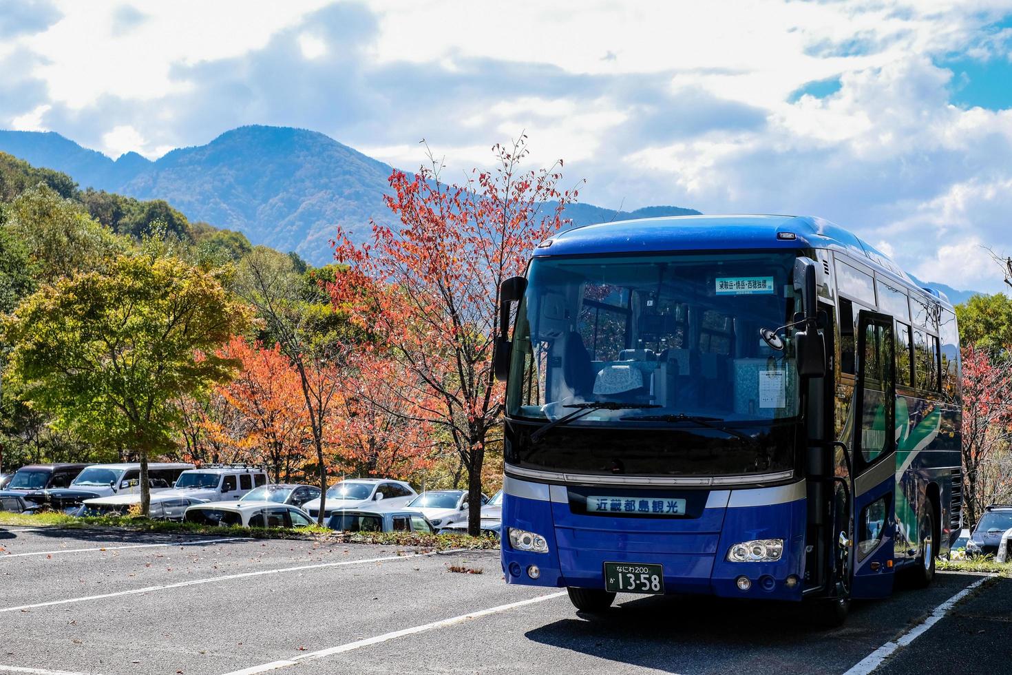 Kamikochi, Nagano, Japan - October 2022 Unidentified tourists bus with a beautiful background of Fall foliage season in Japan alps. photo