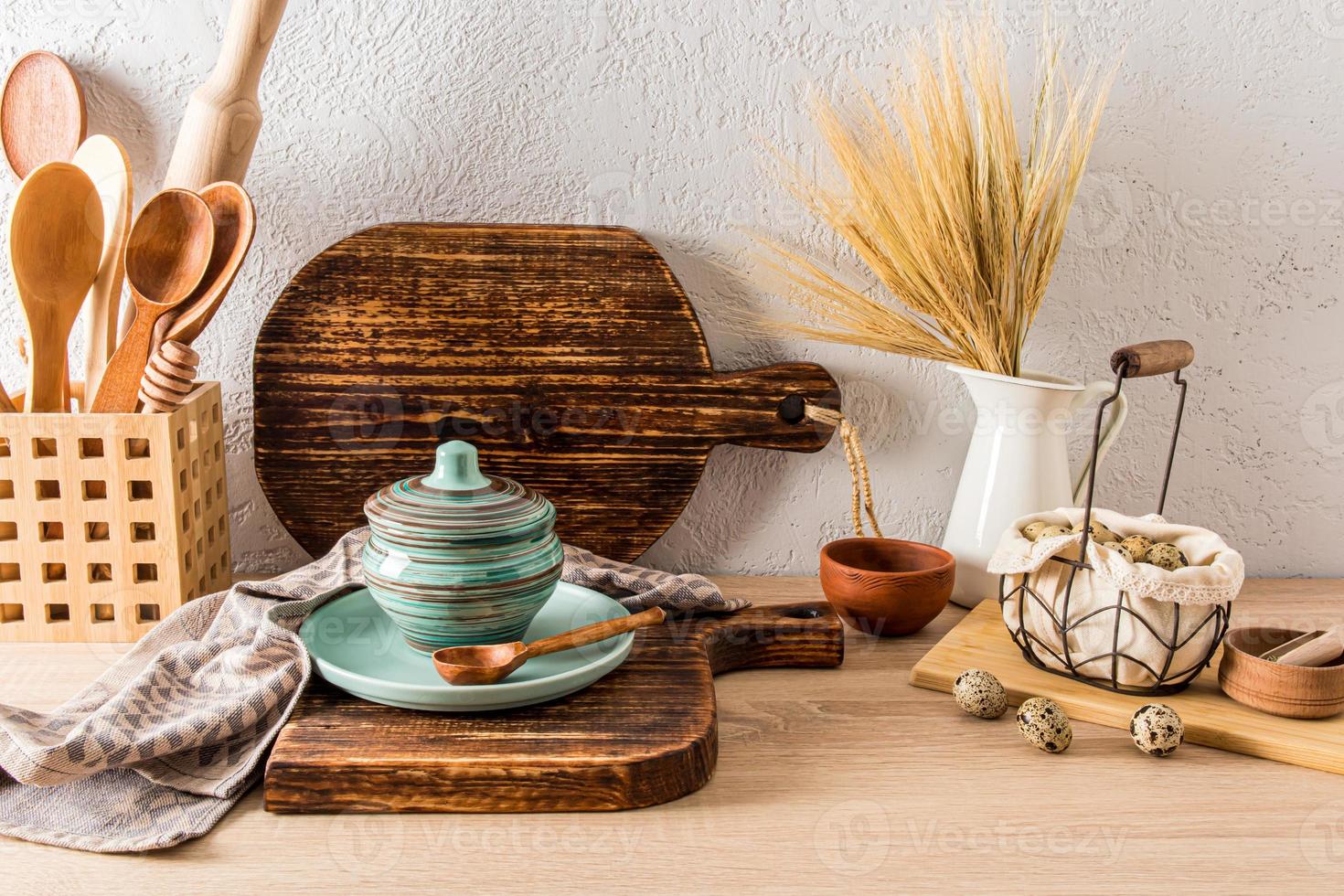 encimera de madera de la cocina de la masía con diversos utensilios de cocina y productos de labranza. el concepto de la decoración de una casa de campo. foto