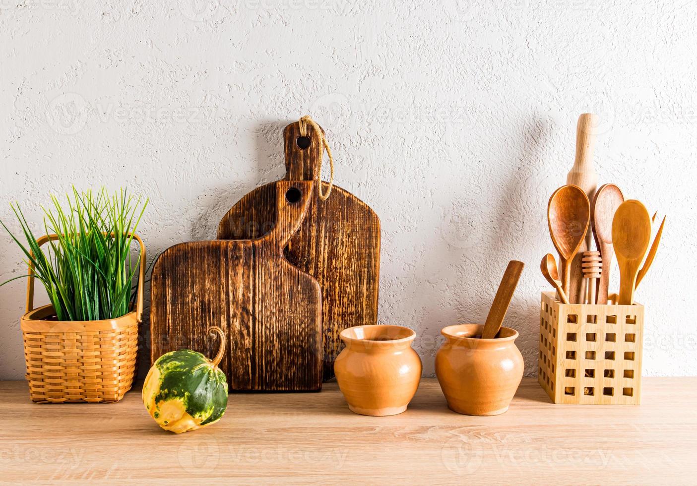 decoración de la cocina casera de una casa de campo. vista frontal de una encimera de madera con utensilios de cocina hechos de materiales ecológicos. foto