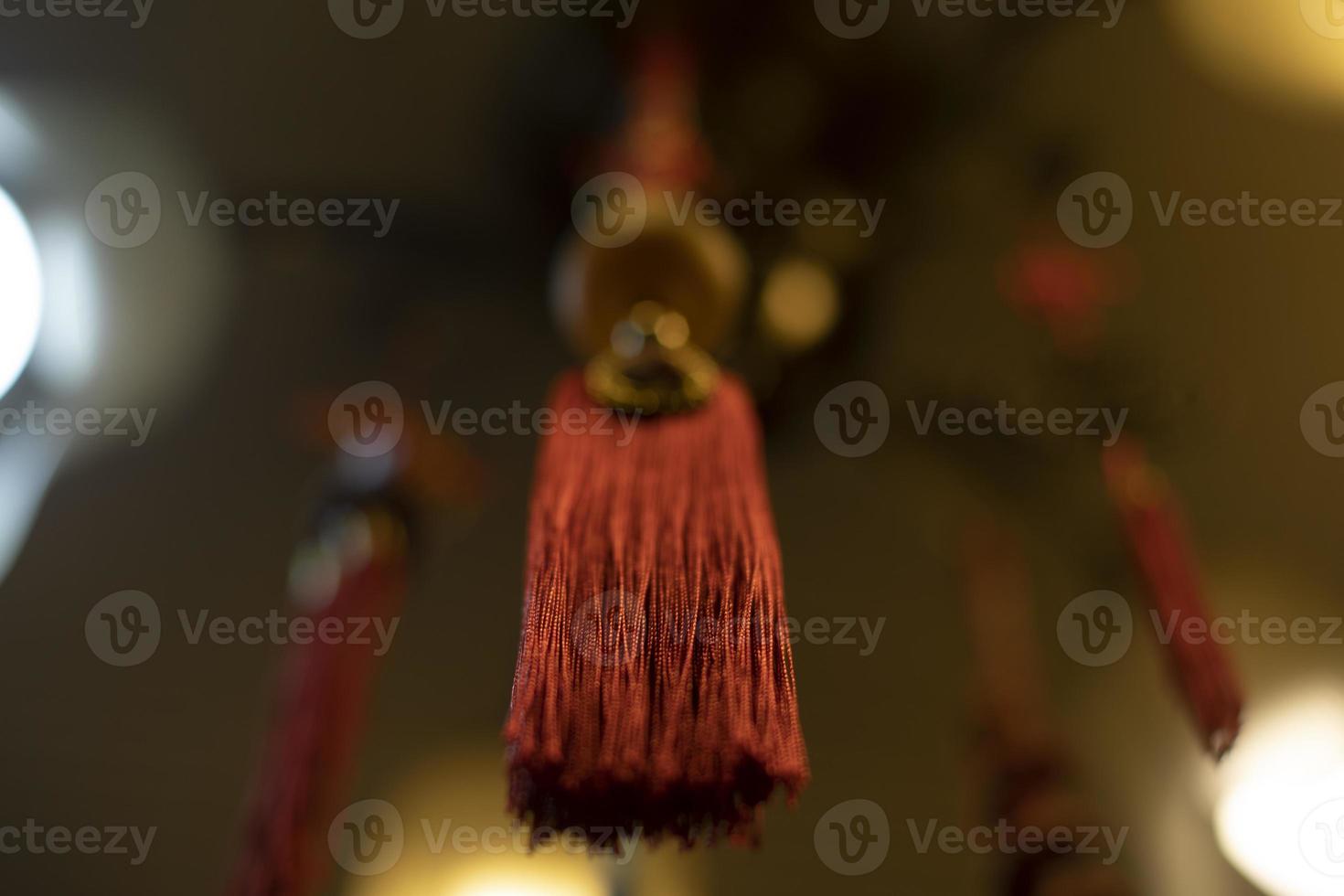 Red cloth hanging from ceiling. Thread brush. Interior decoration. Indian Decoration. Details of light in room. photo