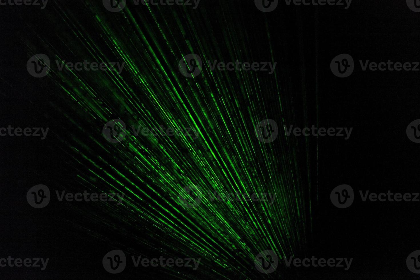 Laser beams in dark. Green rays on black background. Light music bright color. photo