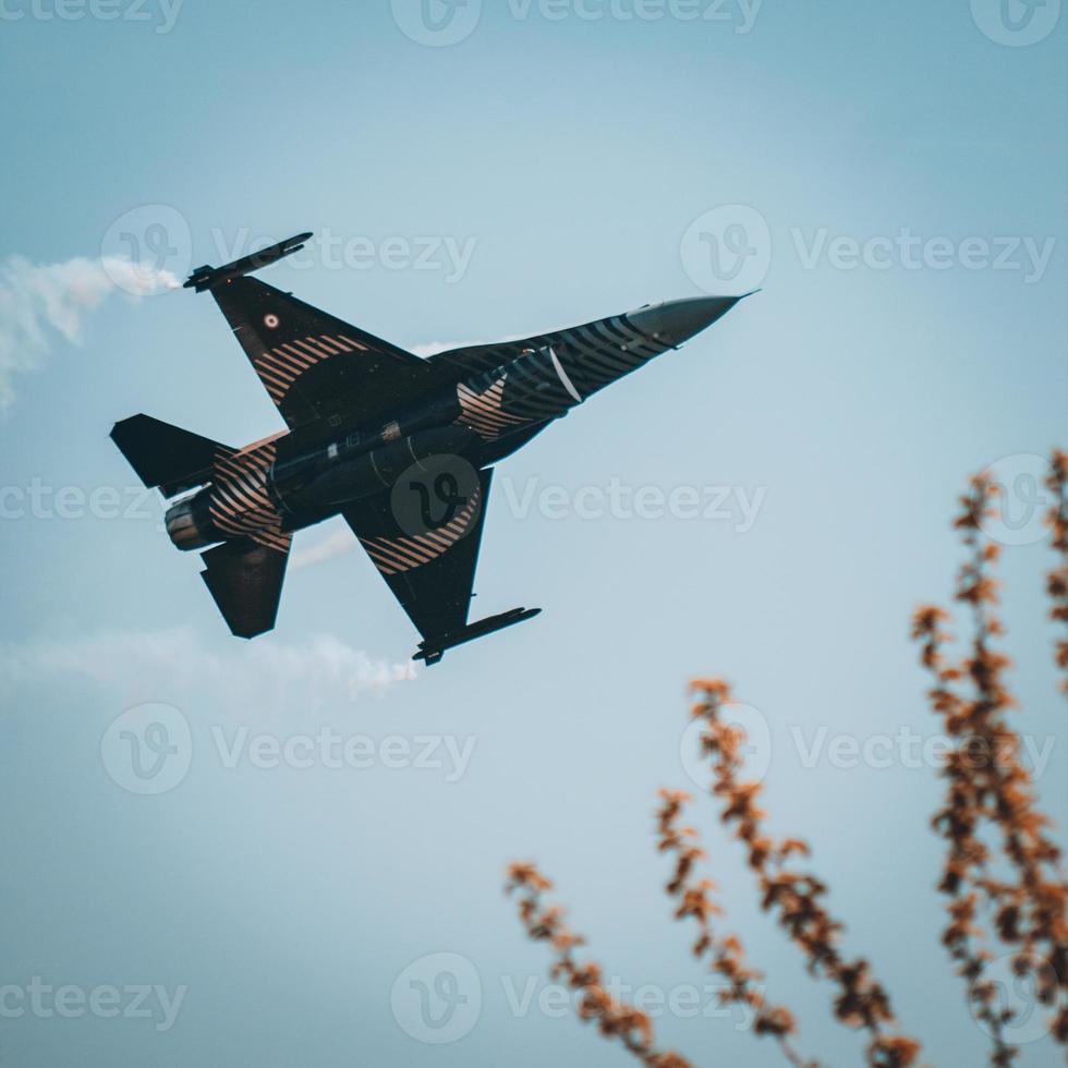 Fighter jet makes a demonstration flight in the blue sky. photo