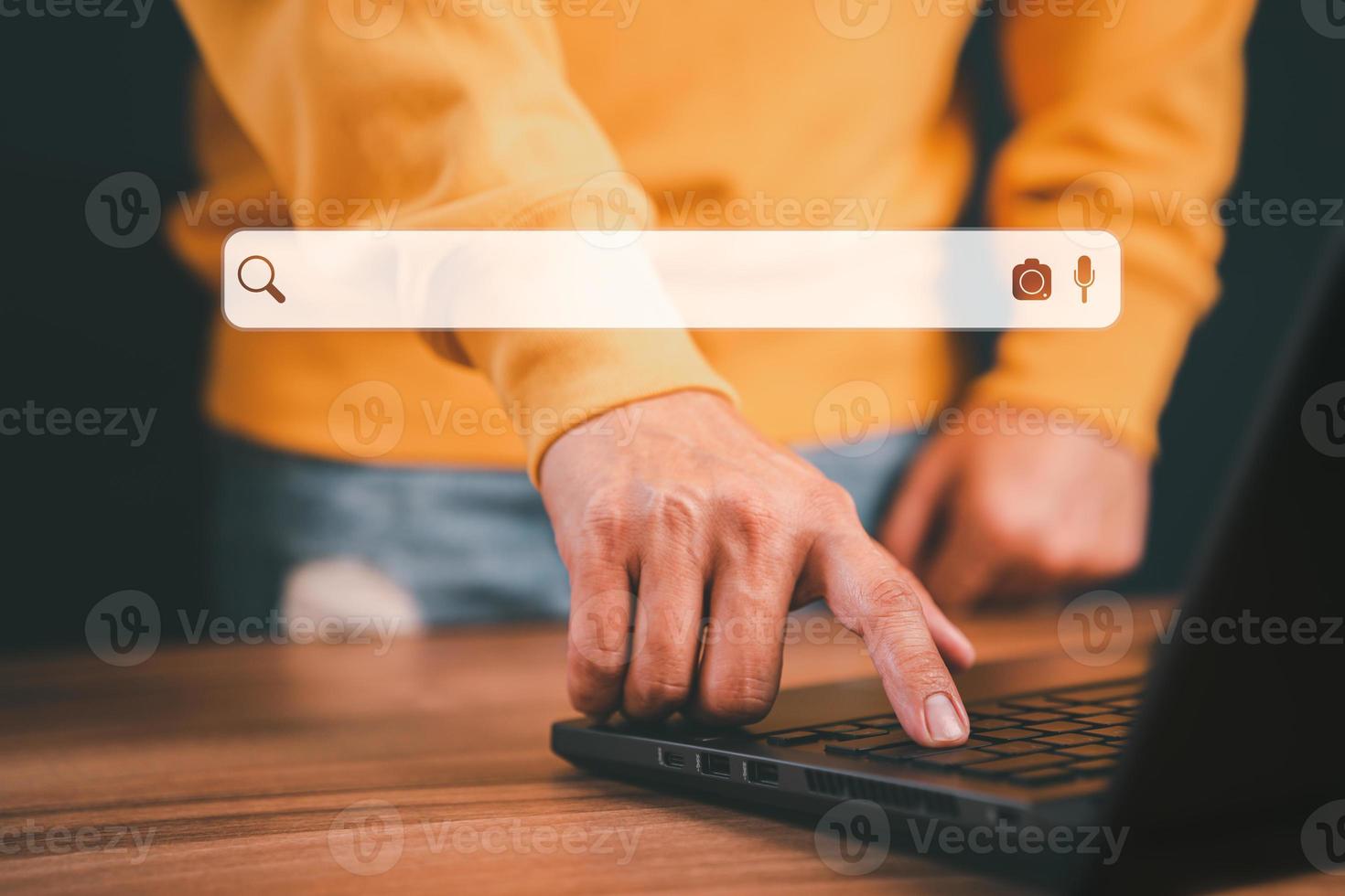 Freelance's hand working with computer laptop on desk in home. Searching Browsing Internet Data Information with blank search bar. Search Engine Optimization SEO Networking Concept. photo