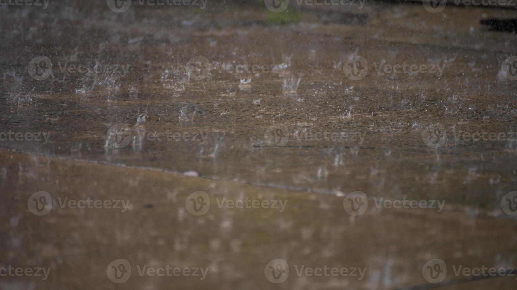 gotas de lluvia en el piso de concreto en el jardín foto