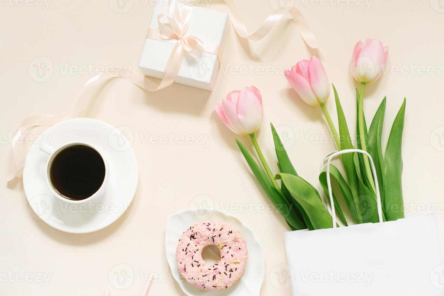 Tulips, gift box and coffee on a beige background. Flat lay. 8 March, International Women's Day. Valentine's Day. photo