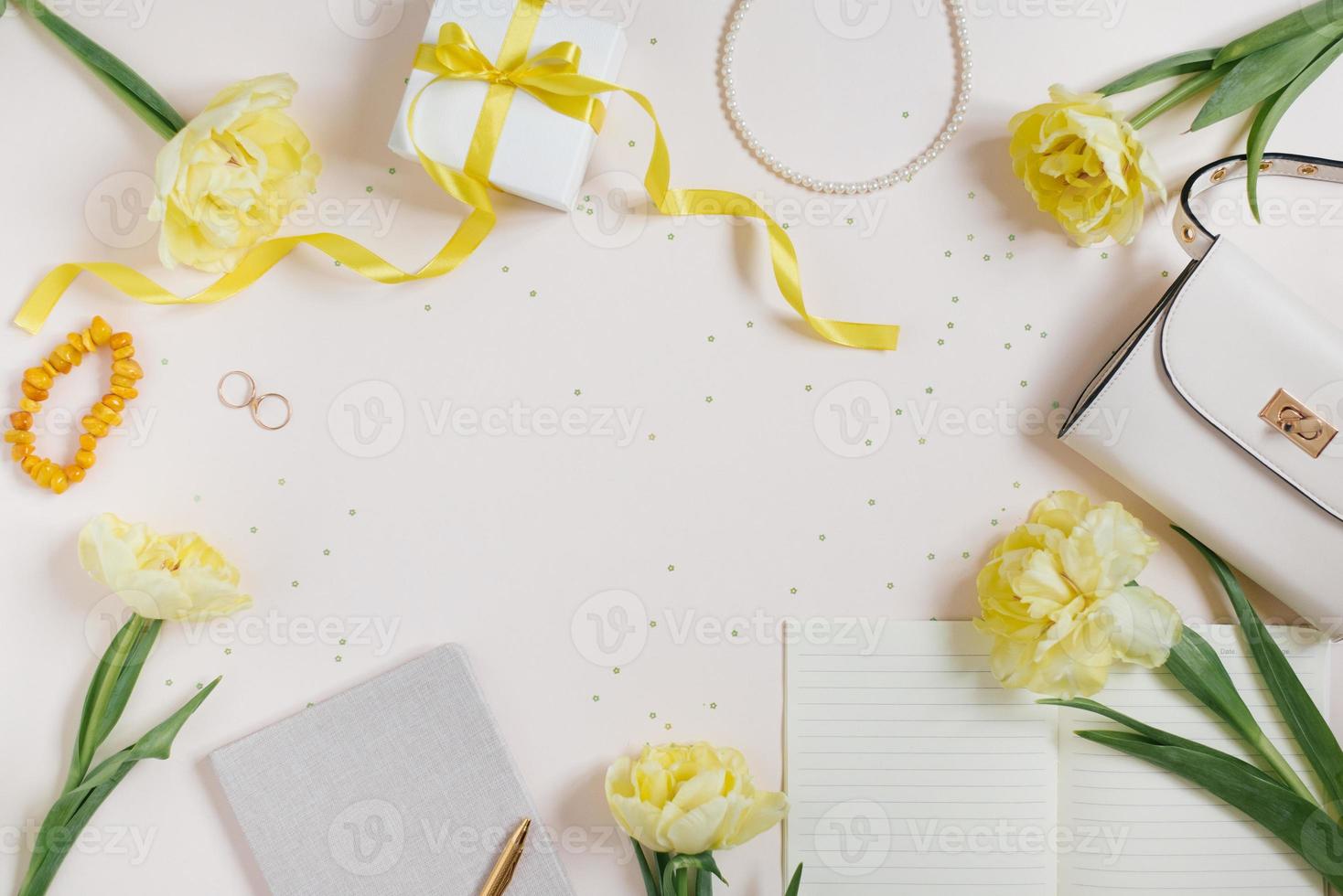 Yellow flowers, spring tulips, cosmetics, women's handbag, gift box with a bow. Flat lay, copy space photo