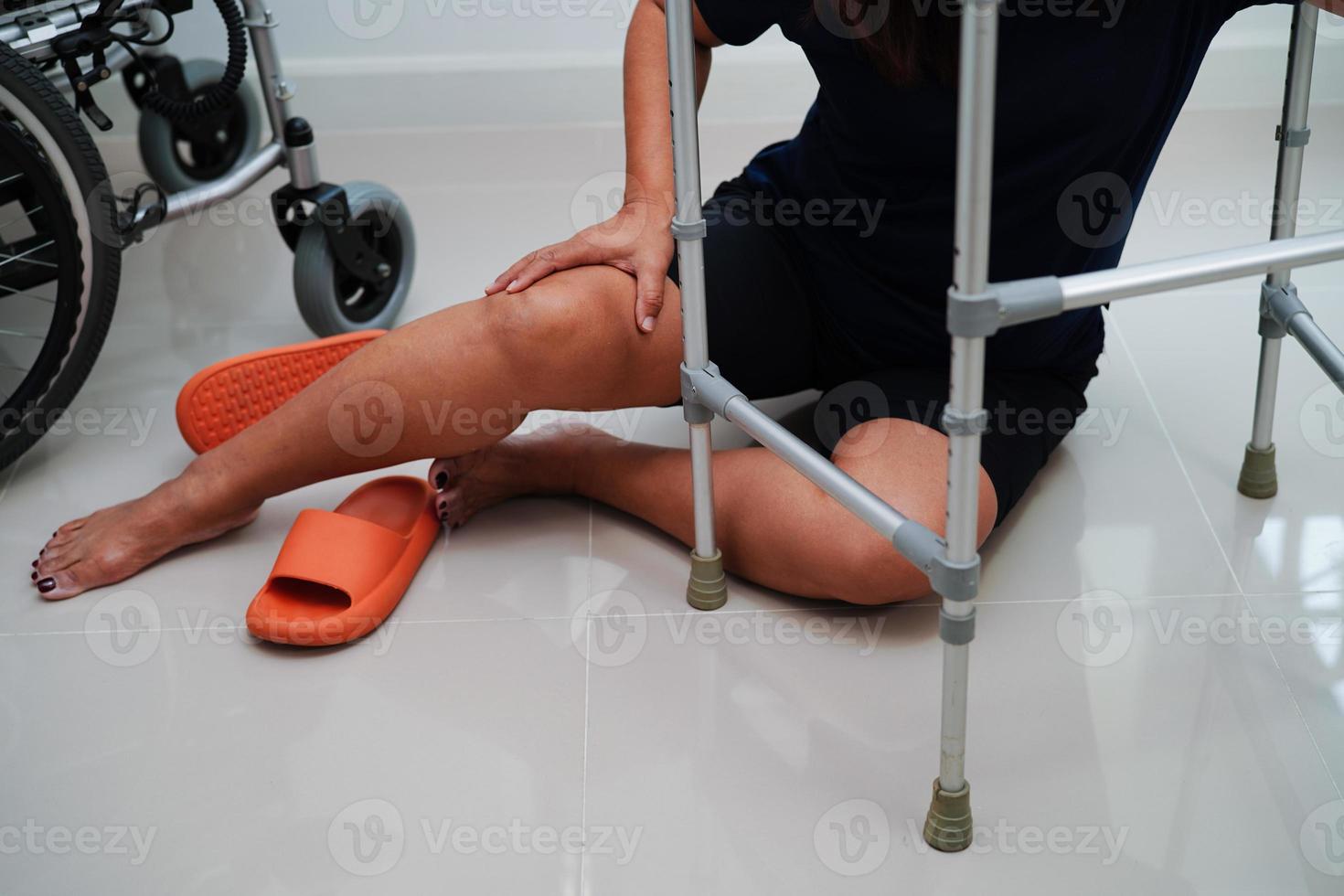 Asian woman injury from falling down on slippery surfaces with walker at home photo