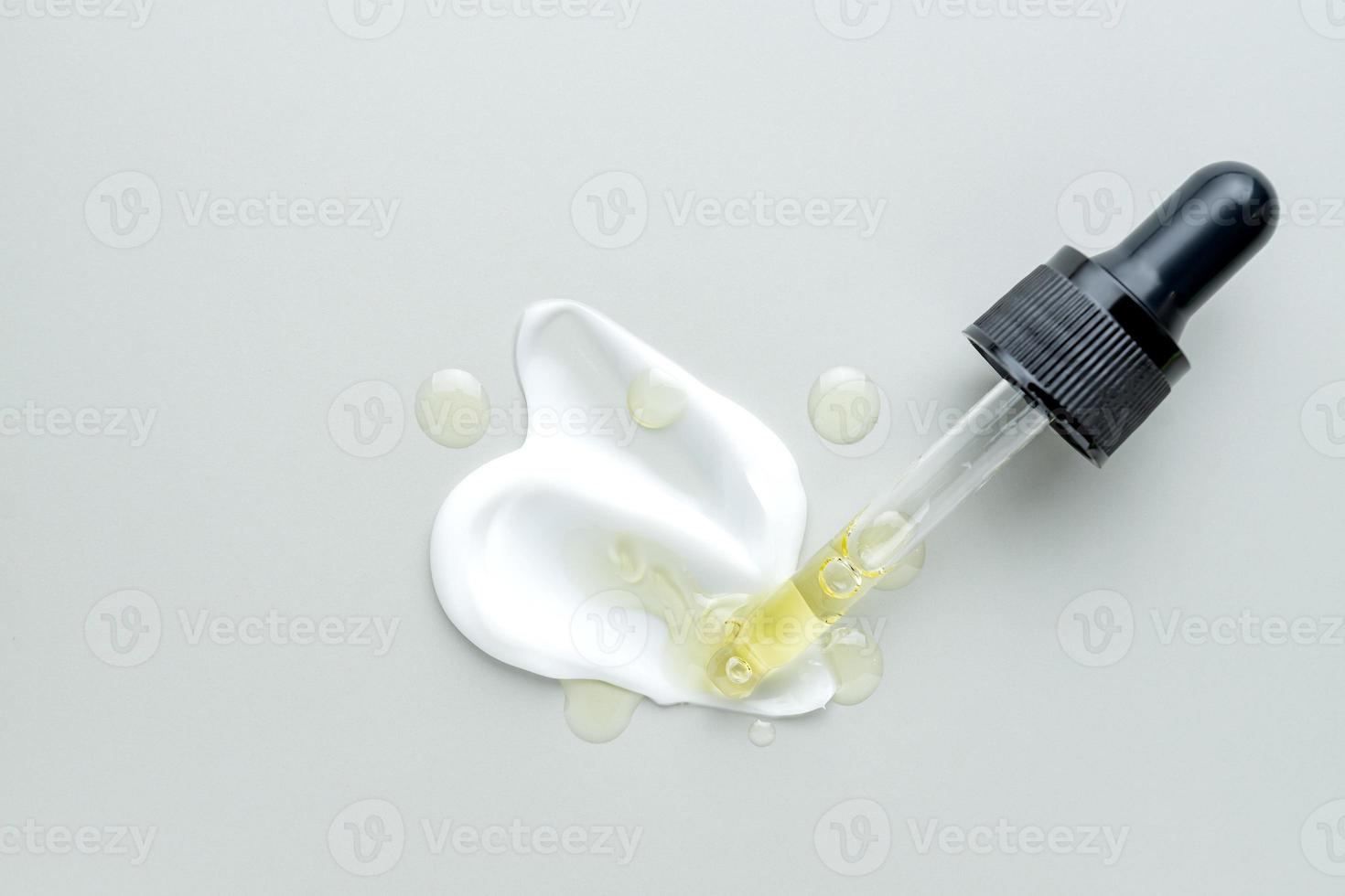 Different skin care product texture swatches on gray background. Essence oil or serum and face cream. Pipette dropper. Cosmetic smears photo