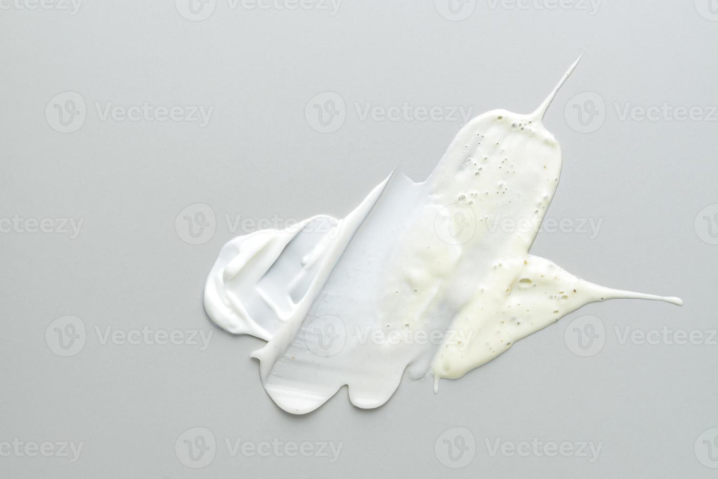 Beauty skin care product textures on gray background. Face cream, exfoliation scrub and cleancing foam smears. photo