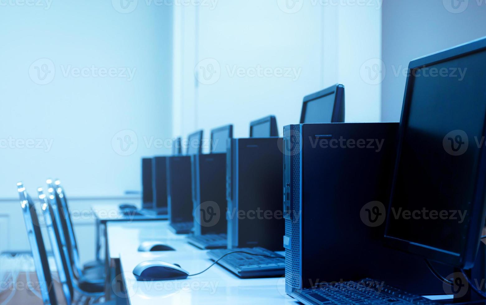 fila de computadoras y monitores en clase de computación foto