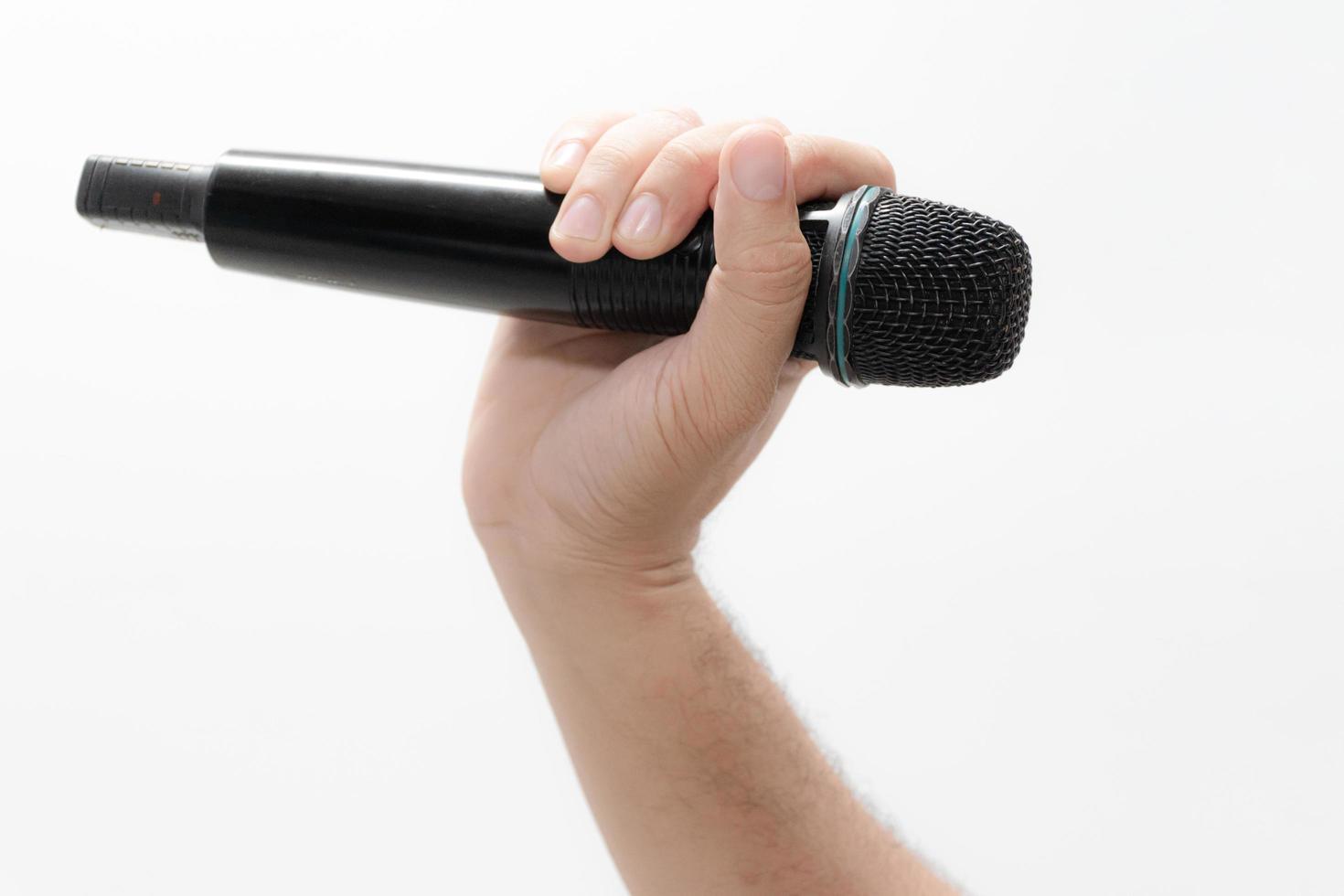 Hand holding a microphone isolated on white background photo