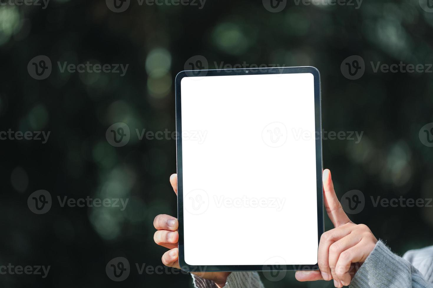 Woman hand holds modern white screen tablet on floral background, Travel concept. Business office ideas. Choice of travel. Copy space. Online store. technology digital cyberspace. web network. photo