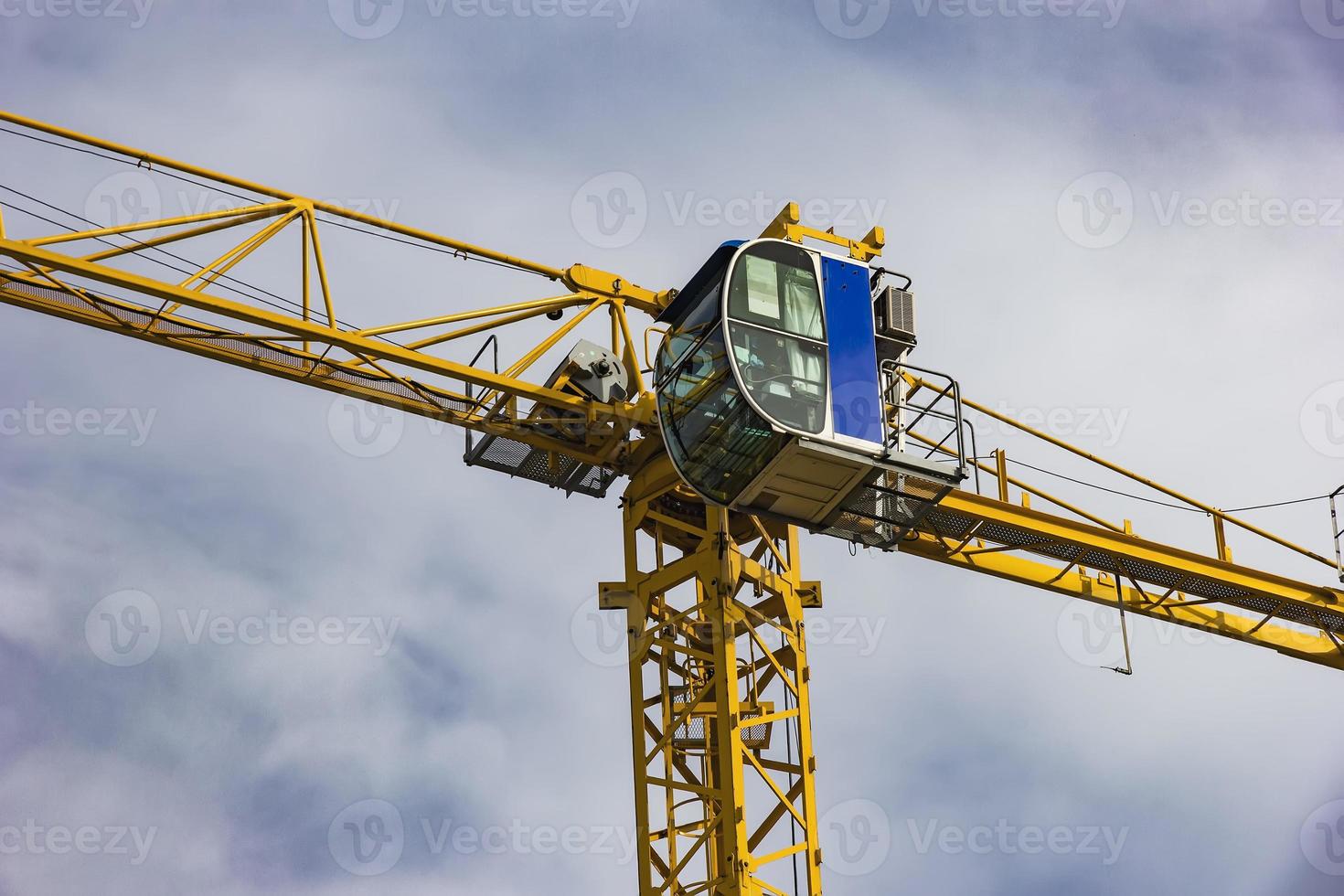 Construction tower crane, cabin, closeup, on blue sky with clouds. photo