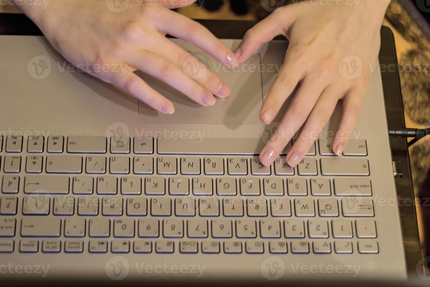 Woman working at home office, hands on laptop keyboard . close up photo