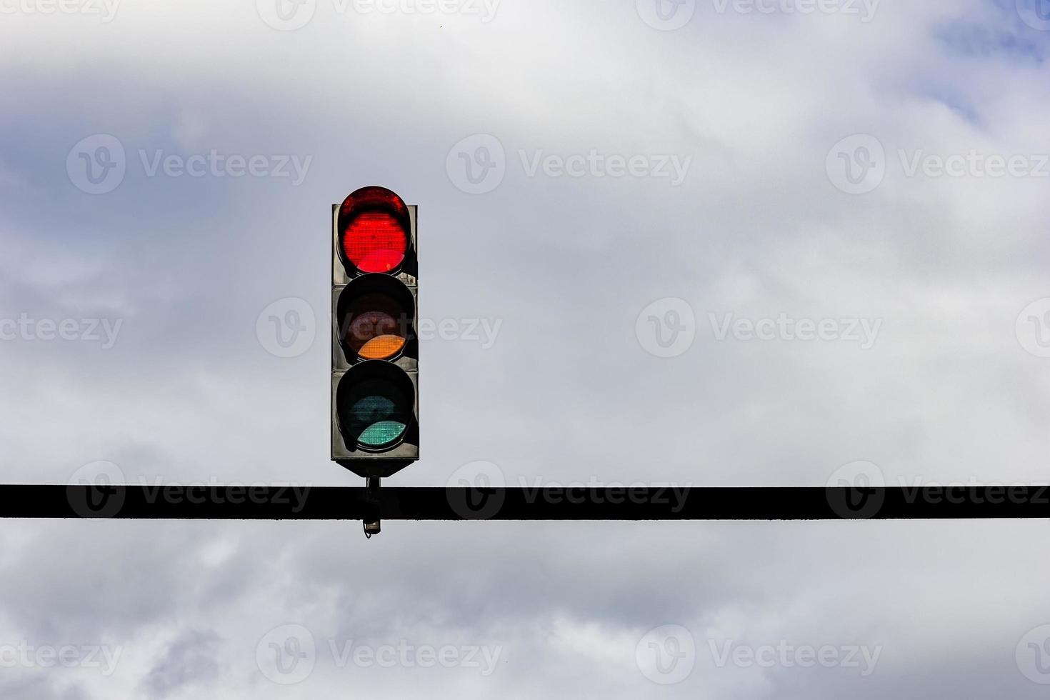 semáforo con luz roja contra el cielo nublado. foto