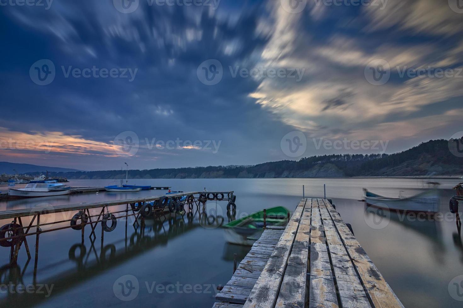 emocionante paisaje marino de larga exposición en el puerto con muelle de madera y barco foto