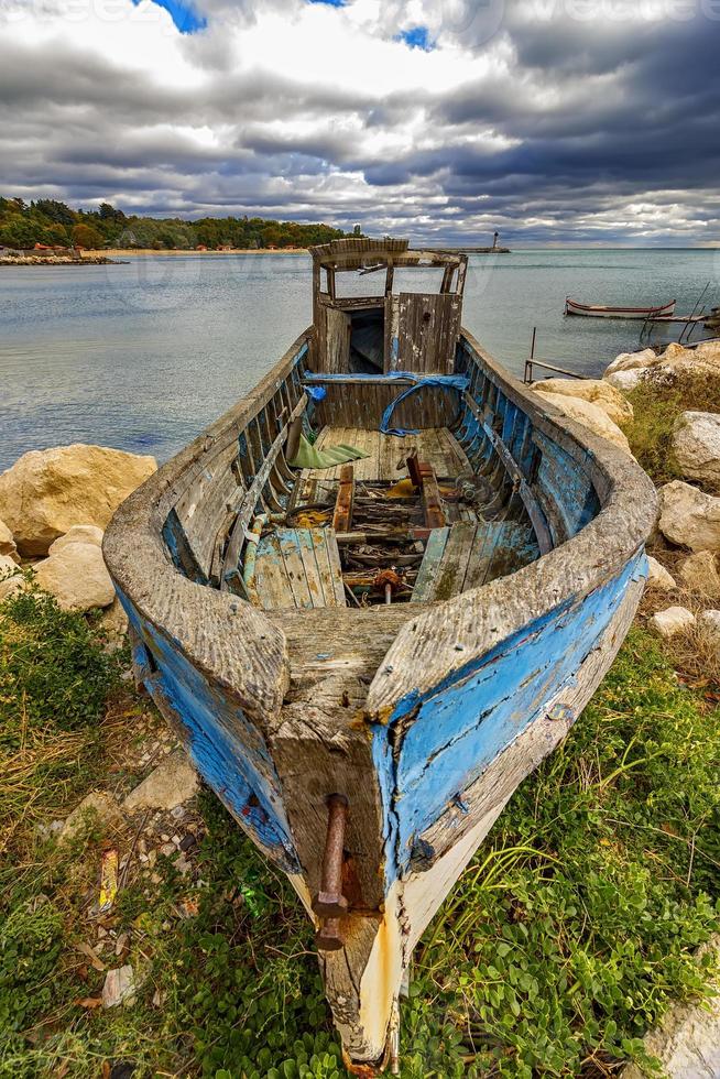 Abandoned old wooden fishing boat on the beach photo