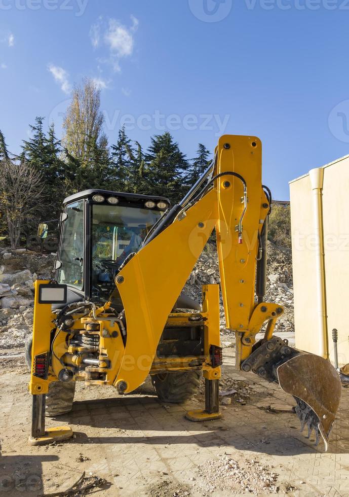 Break. Yellow excavator with shovel at construction site photo