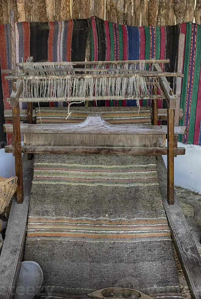 A traditional vintage bulgarian weaving loom with rug photo