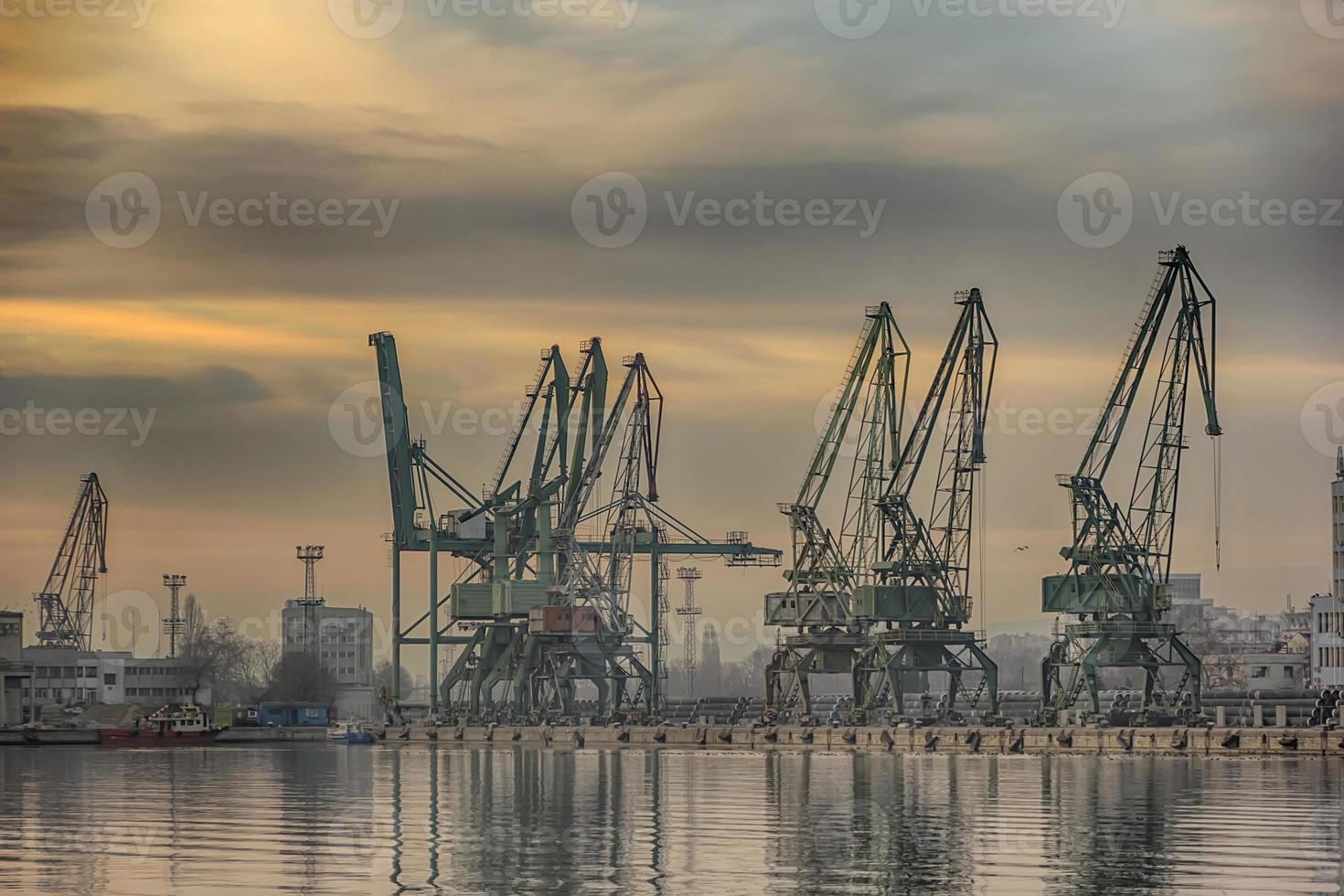 In the evening, the silhouette of port cranes.Ready to load containers from cargo ships. photo