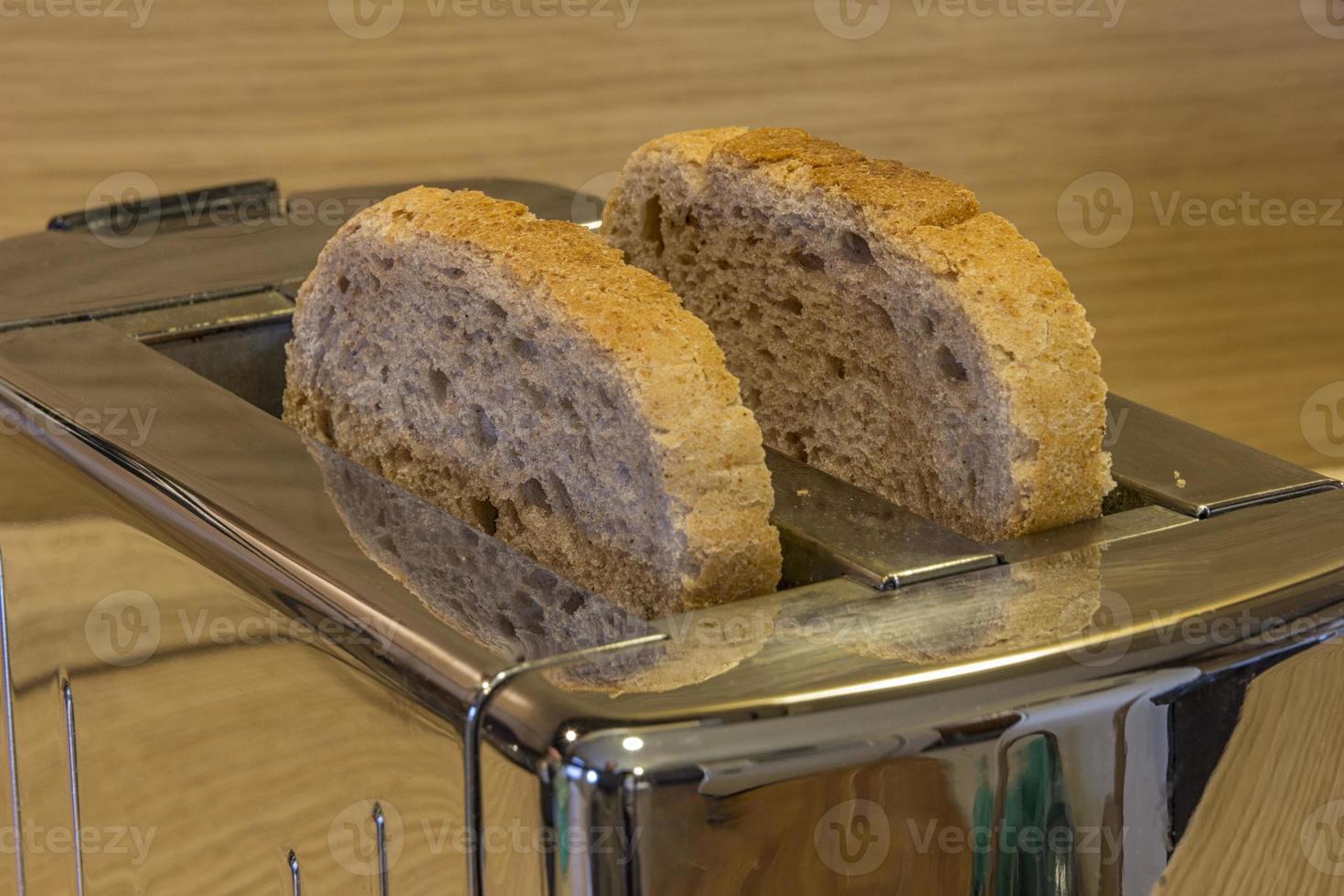 Rebanada de pan lista para tostar con tostadora, menaje de cocina. de cerca. foto
