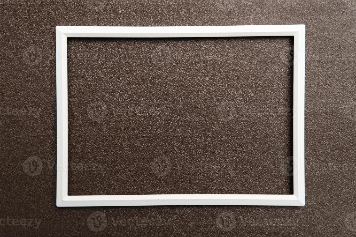 White rectangular blank frame on brown textured background. Copy space. Top view. photo