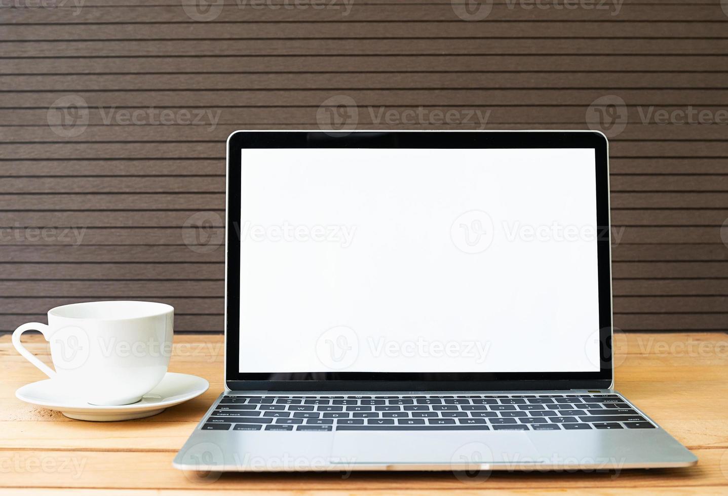 Coffee cup with laptop mockup on wood photo