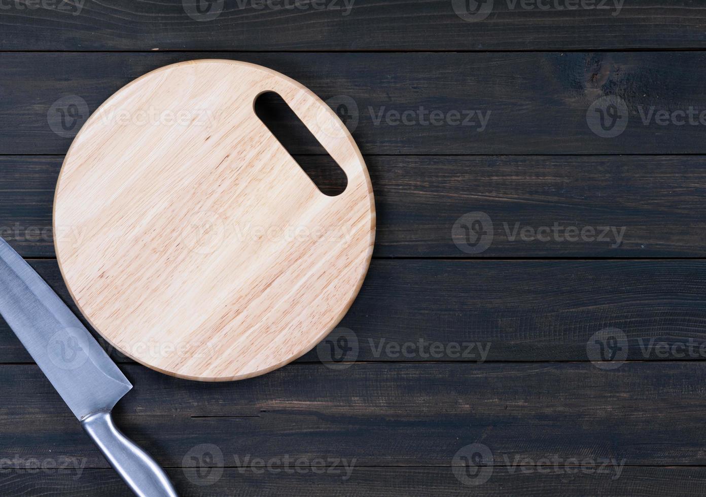 Close up kitchen knife and wooden round cutting board photo