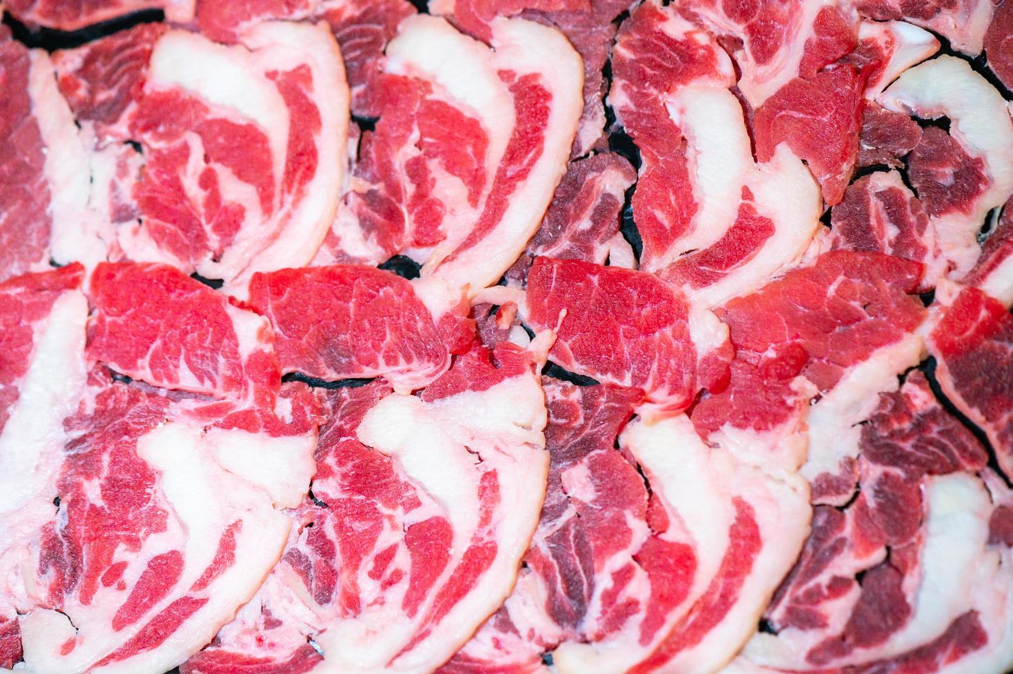 deslice la carne cruda para yakiniku. carne de res fina para el estilo de comida japonesa shabu hotpot. cierre el ojo de la carne fresca para sukiyaki. vista superior foto