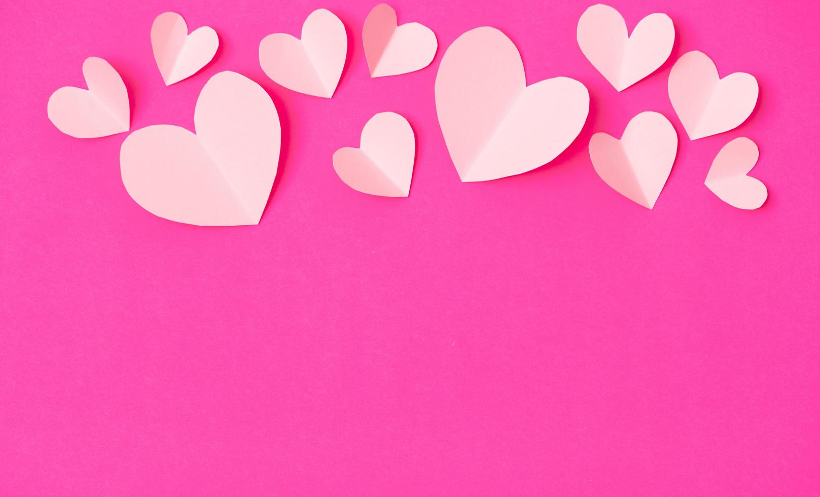 Shape of heart flying on pink paper background. photo