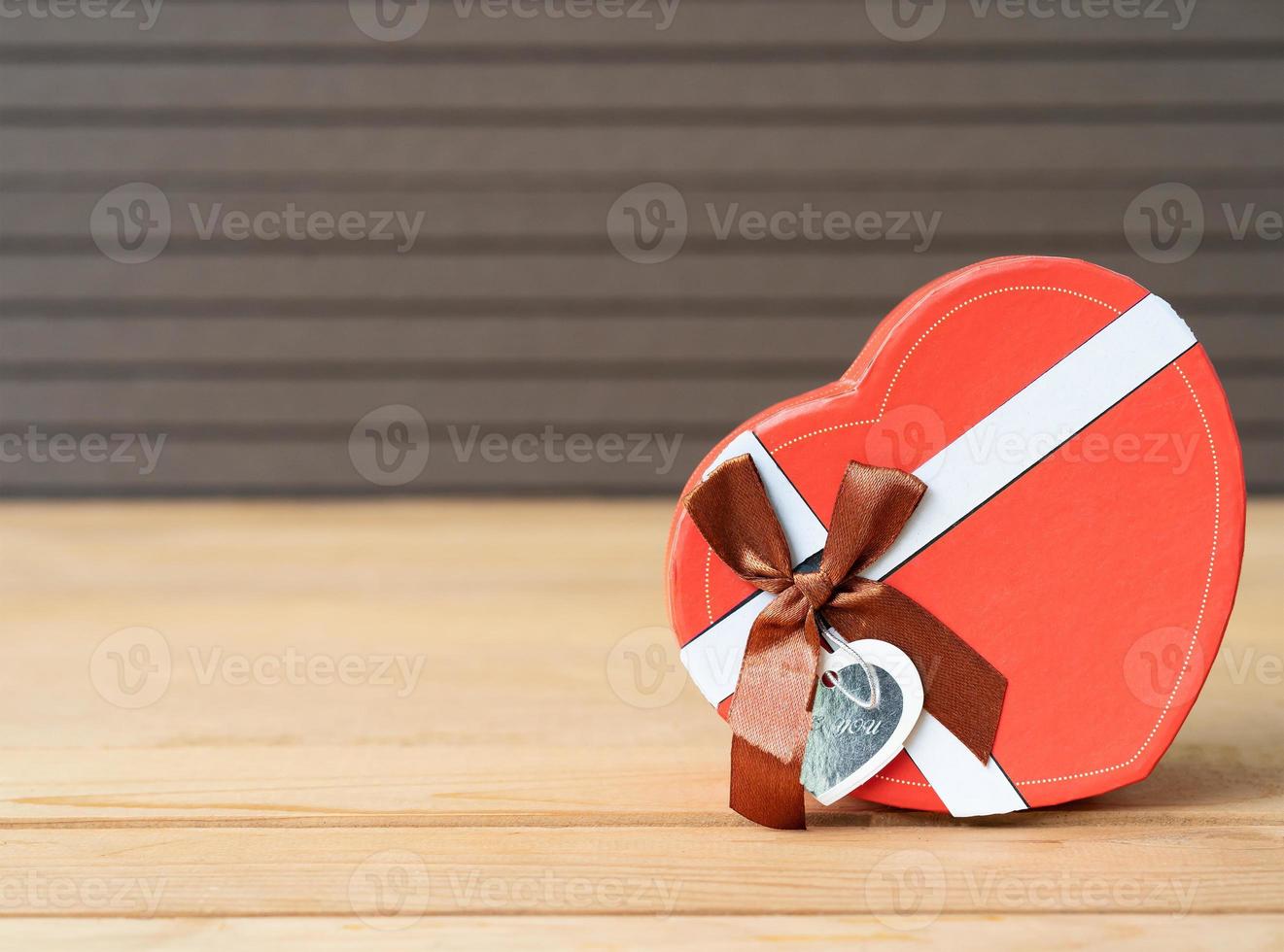 Heart-shaped box on wood background photo