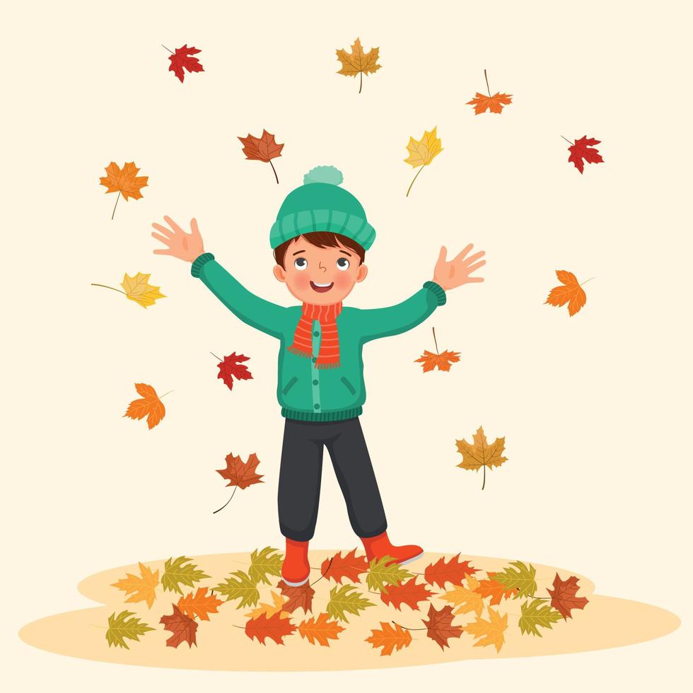 happy little boy playing outside with fallen leaves in autumn vector