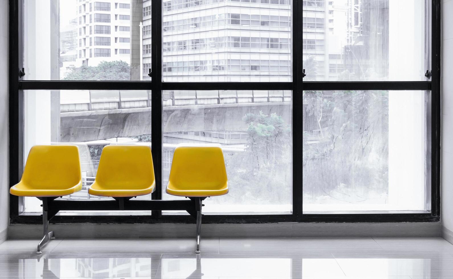 silla de espera amarilla en el vestíbulo con fondo de vista del edificio y espacio de copia foto