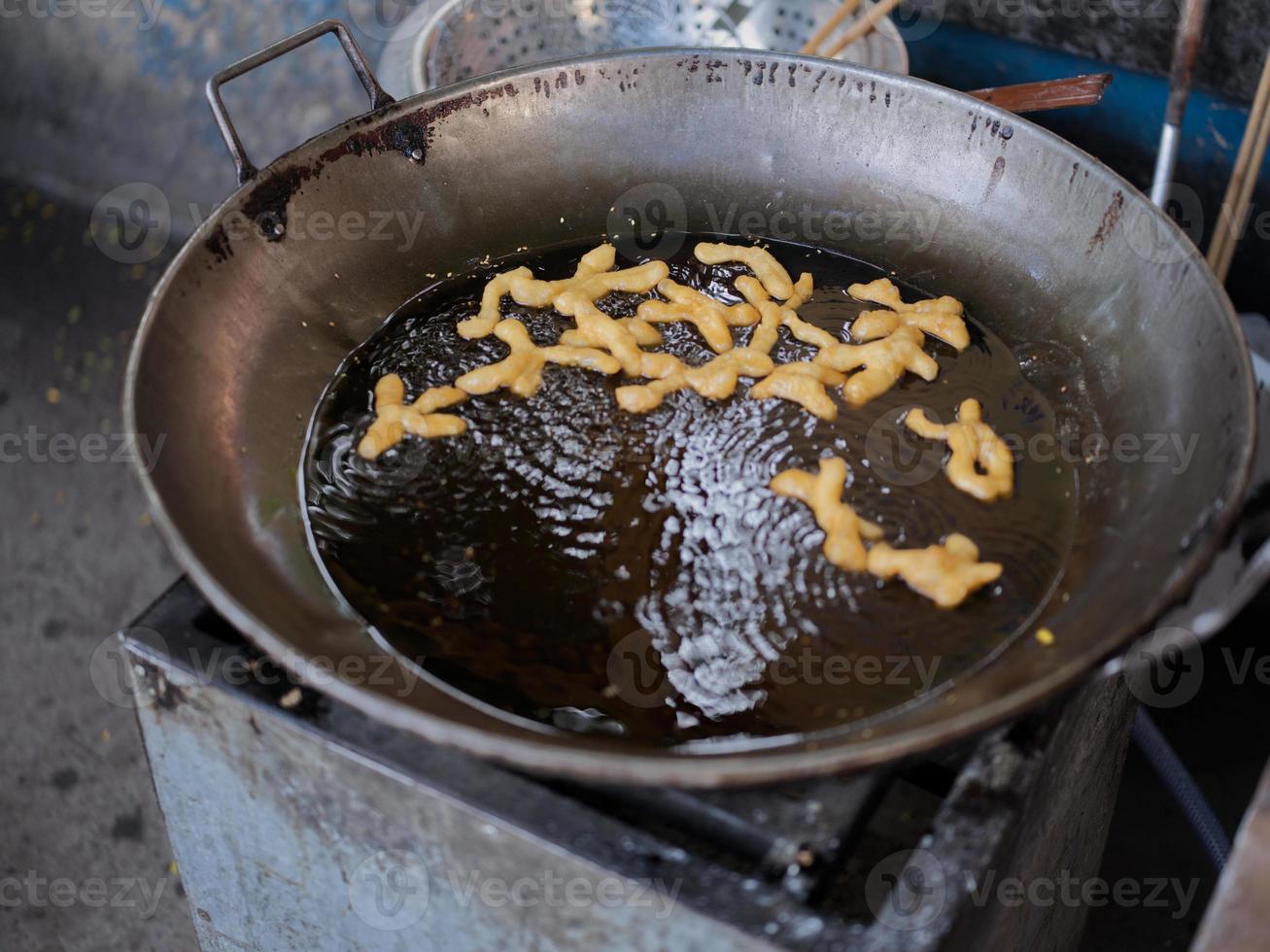 Die cut of Deep fried Chinese Doughnut in an big oil pan photo