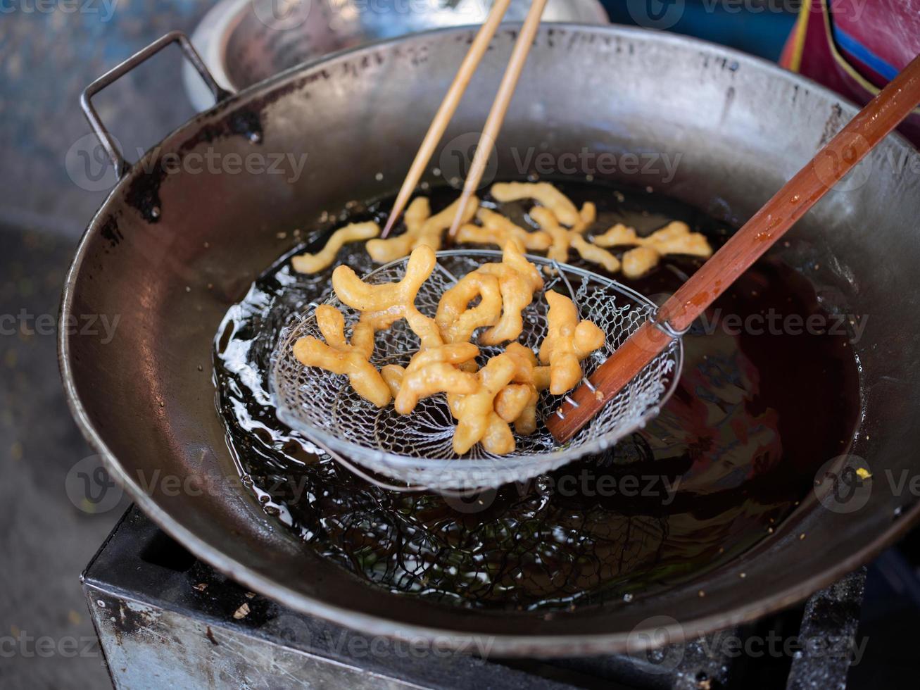 Die cut of Deep fried Chinese Doughnut in an big oil pan photo