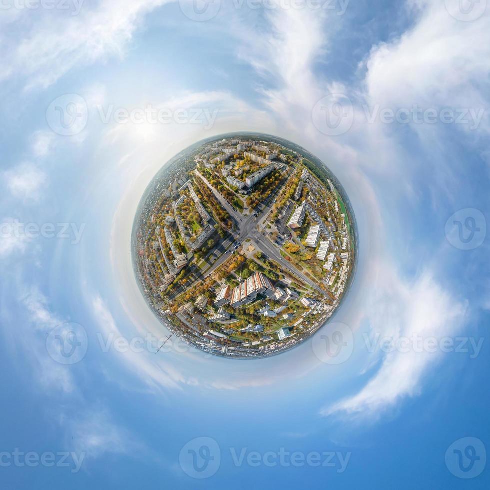 tiny planet in sky with clouds overlooking old town, urban development, historic buildings and crossroads. Transformation of spherical 360 panorama in abstract aerial view. photo