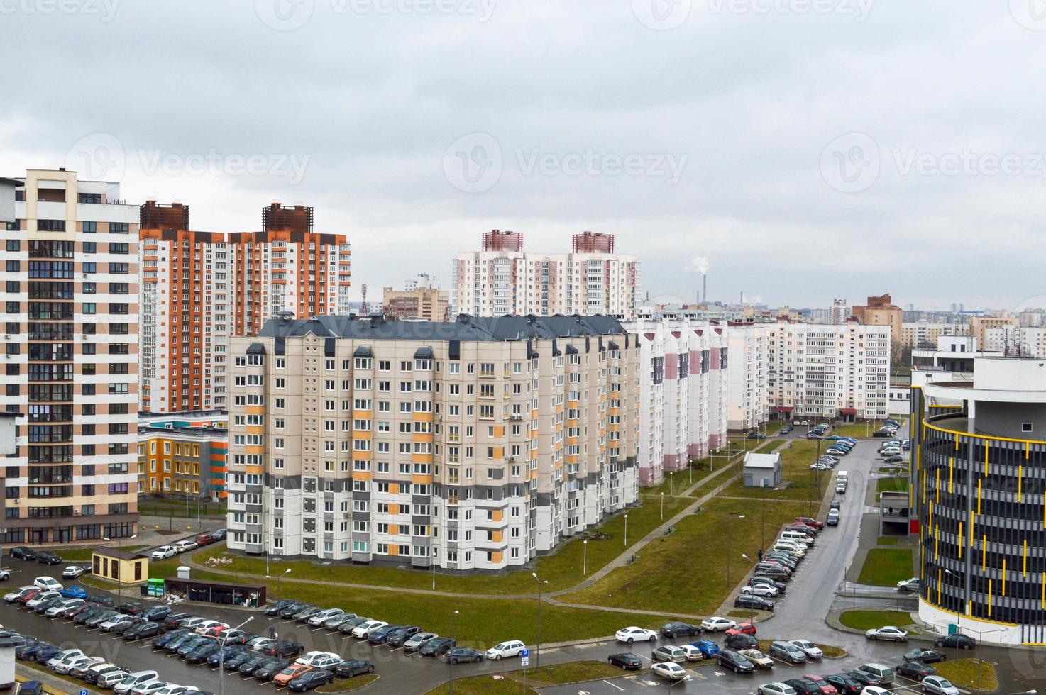 vista superior de una gran ciudad moderna con casas, edificios de varios pisos y arquitectura, estacionamiento y muchos autos foto