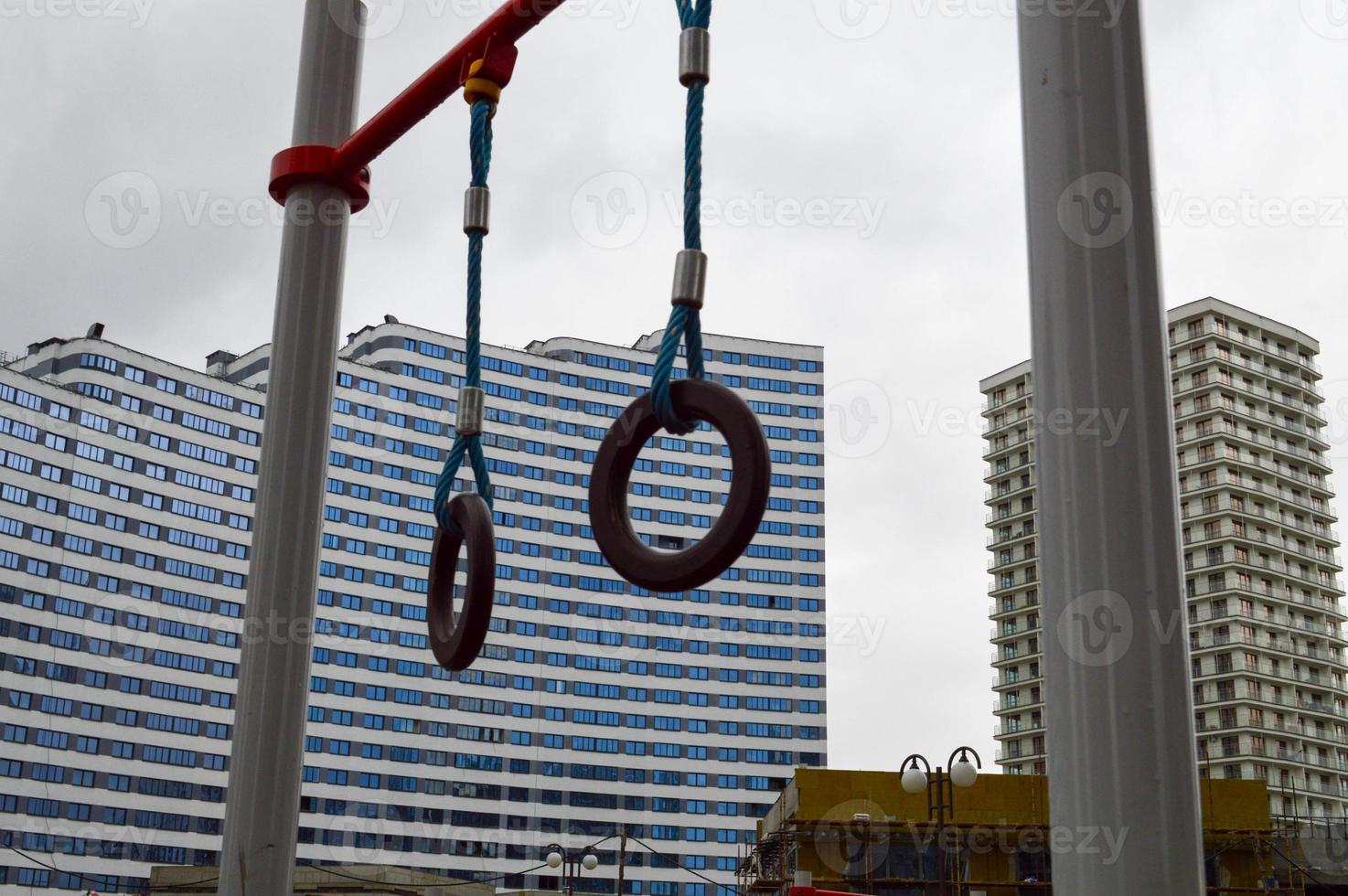 Sports rings on the street under the open sky for sports against the background of the house in the new district of the city in the courtyard of the new building photo