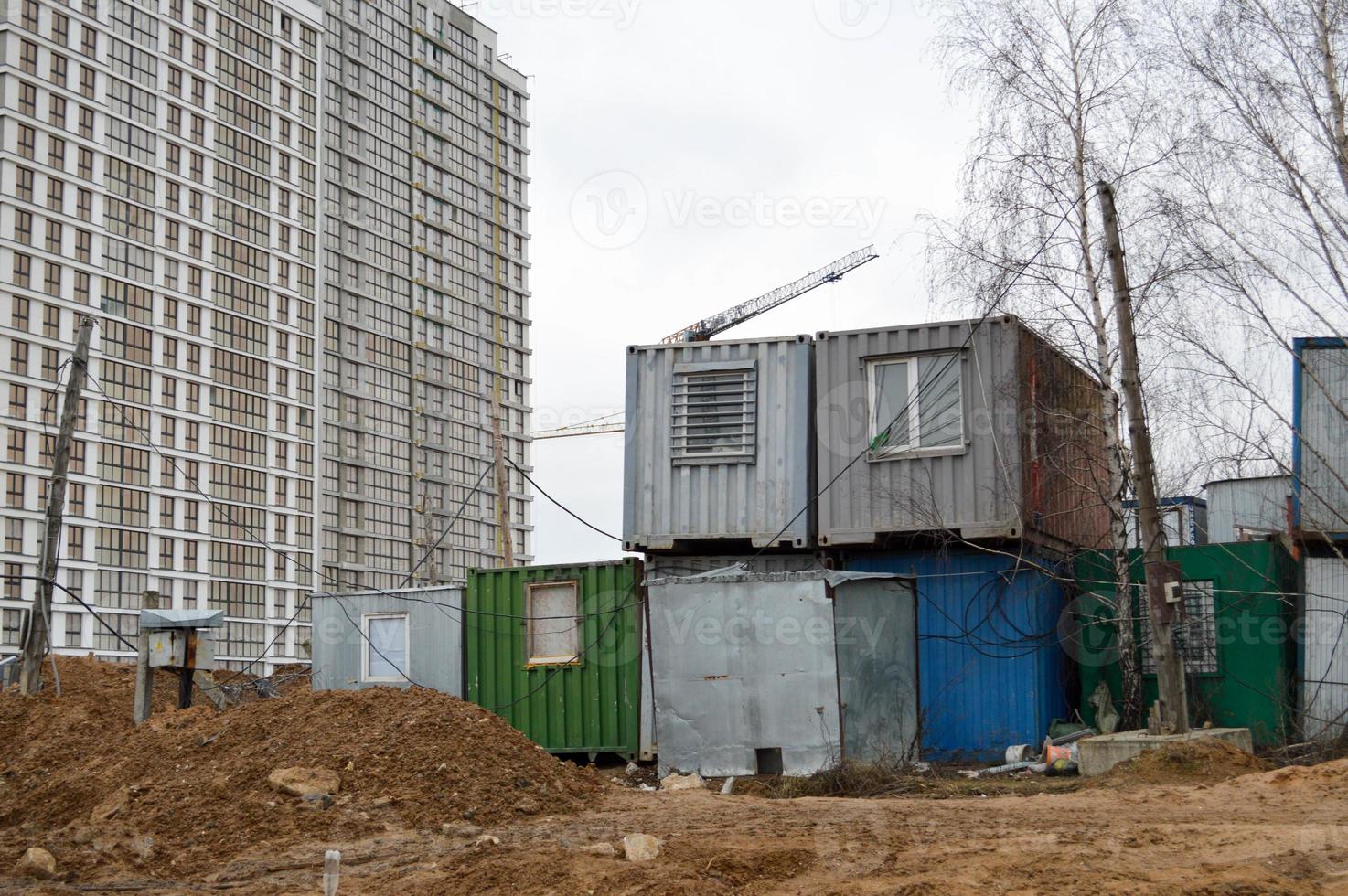 Small temporary houses of builders from containers at an industrial construction site. Block-modular construction city with change houses for workers photo