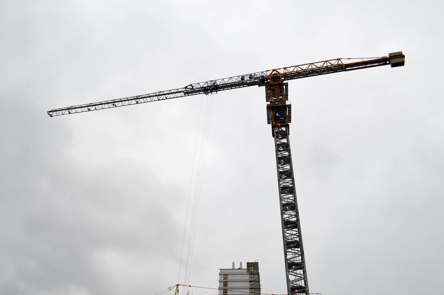 Large powerful construction cargo industrial crane on a construction site of new buildings and houses against the sky photo