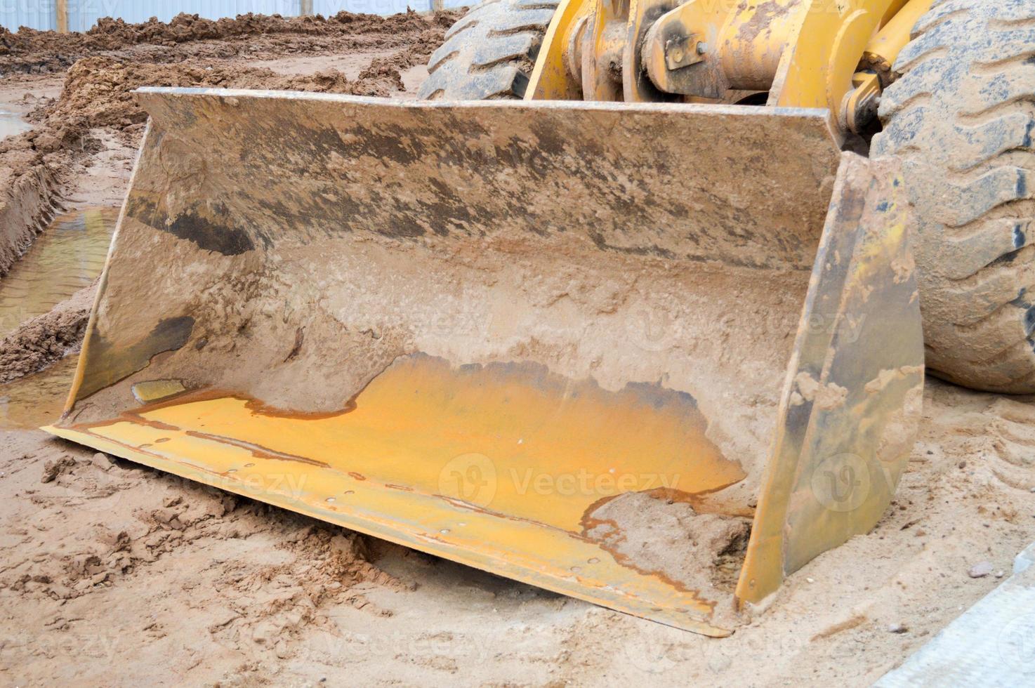 Large iron metal industrial heavy bucket of excavator, bulldozer, specialized construction equipment for road repair and excavation of the earth photo
