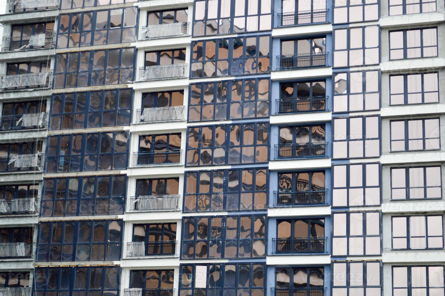 hermosas y modernas ventanas de fibra de vidrio azul de la pared de la fachada de una moderna casa de construcción de rascacielos. fondo, textura foto
