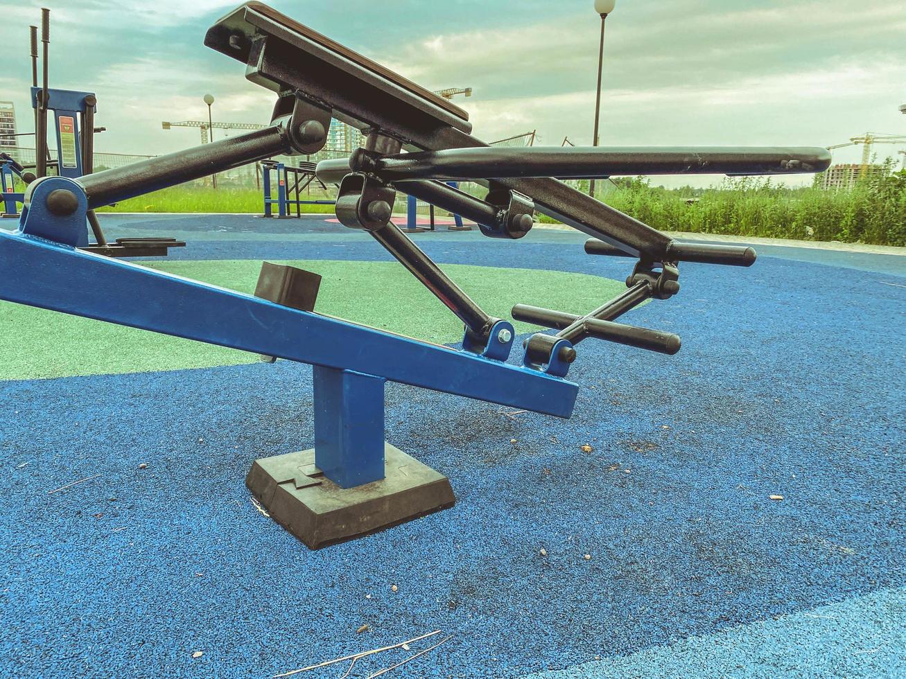 haciendo deportes en el simulador en el parque al aire libre. simulador de bombeo de espalda, piernas y prensa. ocio activo, tiempo al aire libre foto