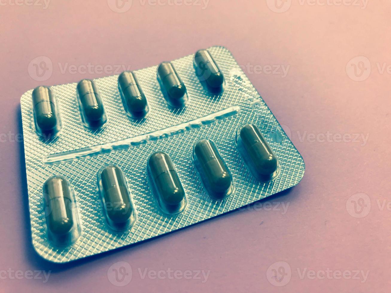 Medical pharmaceutical brown medications for the treatment of diseases and the killing of microbes and viruses tablets and vitamins blisters blisters from coronavirus covid-19 on a pink background photo