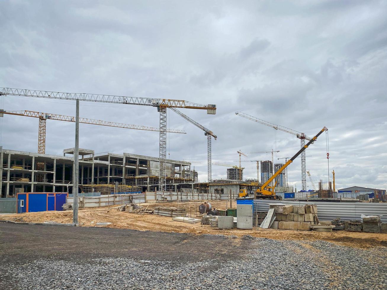 sitio de construcción con grúas para la construcción de edificios altos de varios pisos. construcción de un centro comercial a partir de bloques de hormigón en el centro de la ciudad foto