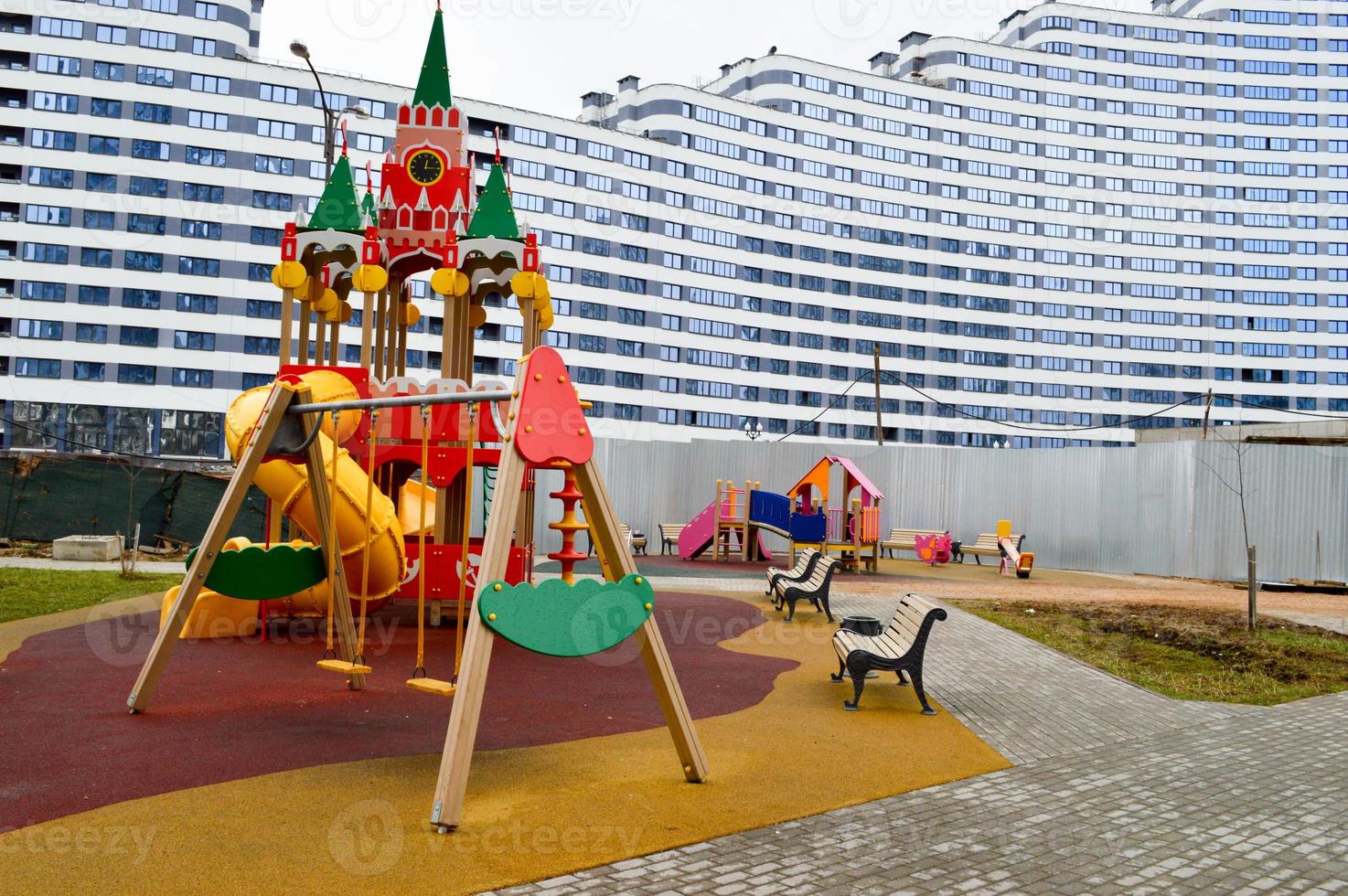 New modern safe outdoor playground in the open air with exercise equipment and toys in a new district of the city in the courtyard of a new building photo