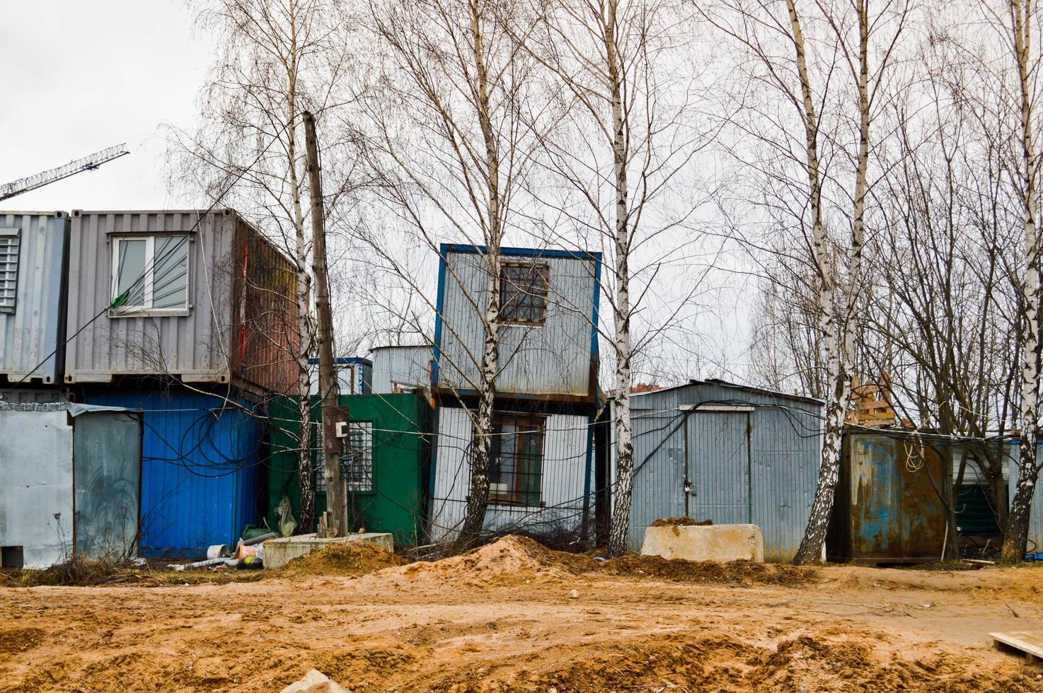 pequeñas casas temporales de constructores de contenedores en un sitio de construcción industrial. ciudad de construcción modular de bloques con casas de cambio para trabajadores foto