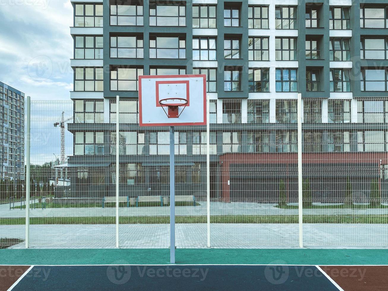 construction of a new residential area in the city center. high-rise block buildings. near a playground for active games for children and a basketball hoop photo