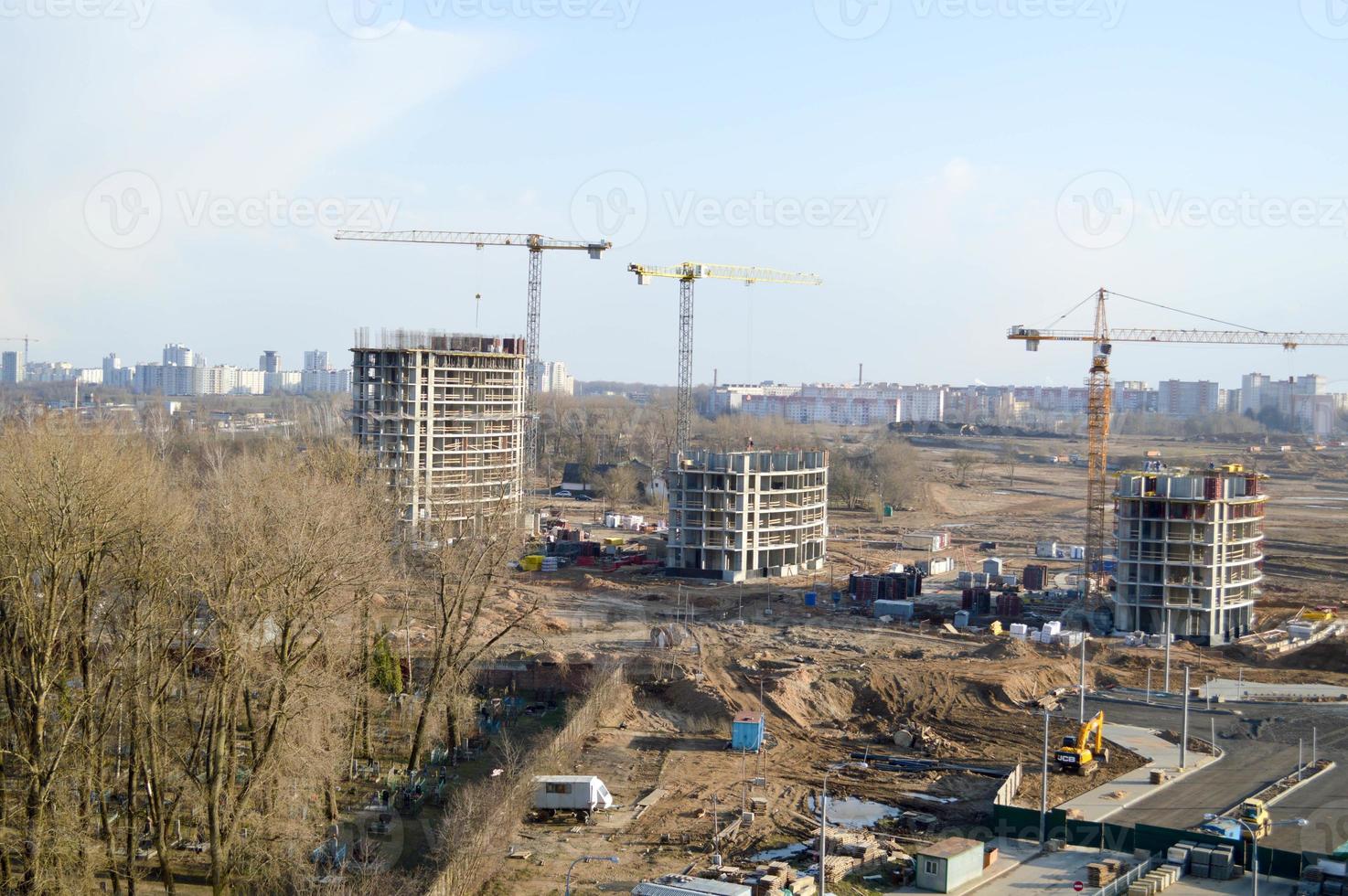 vista superior de un gran sitio de construcción con grúas y edificios que albergan rascacielos monolíticos de hormigón de varios pisos de la gran ciudad de la metrópolis foto