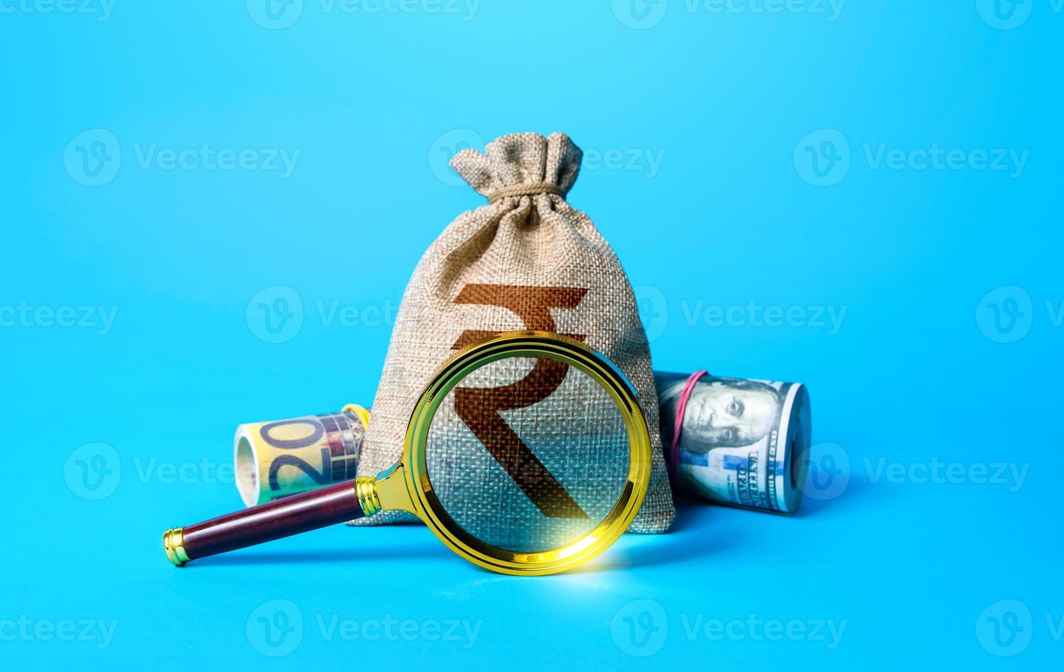 Indian rupee money bag and magnifying glass. Investigating capital origins. Anti money laundering, tax evasion. Deposit or loan terms and conditions. Find investment funds for business project. photo